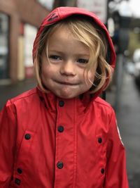 Boy wearing red raincoat looking away