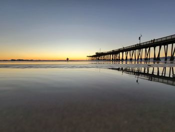 Bridge over sea against sky during sunset