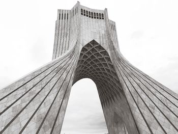 Low angle view of skyscrapers against cloudy sky