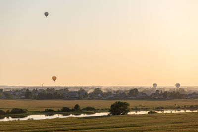 Colorful hot air balloons soar in the sky at dusk or dawn. flight over the fog at sunrise or sunset.