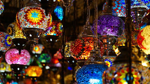 Colorful illuminated lanterns hanging in market for sale