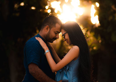 Side view of young couple kissing outdoors