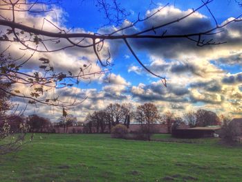 Fence on field against cloudy sky