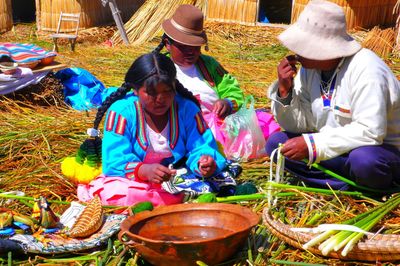 Family sitting at market stall on sunny day