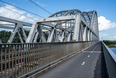 The steel structure of a railway bridge with steel beams and columns and an arch