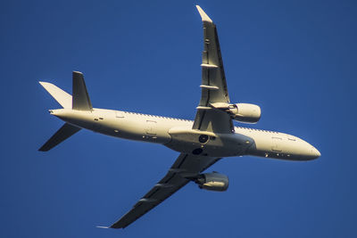 Low angle view of airplane against clear blue sky