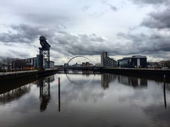 Bridge over river against cloudy sky