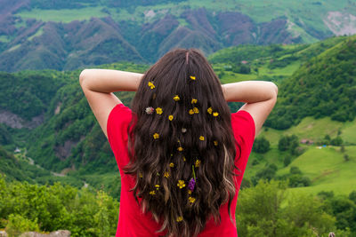 Rear view of woman with arms raised