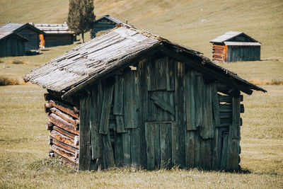 Abandoned wooden cottage on field