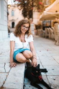 Full length of woman sitting in city