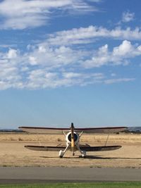 Air vehicle parked on field against sky