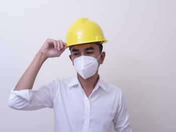 Midsection of man wearing mask against white background
