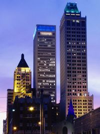 Low angle view of illuminated skyscrapers against sky at night