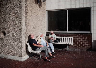 People sitting on wall of building