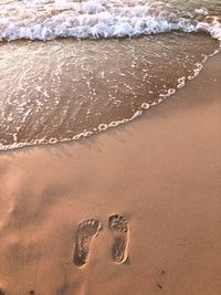 High angle view of footprints on sand at beach