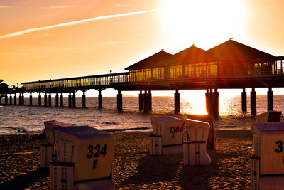 Pier over sea against sky during sunset