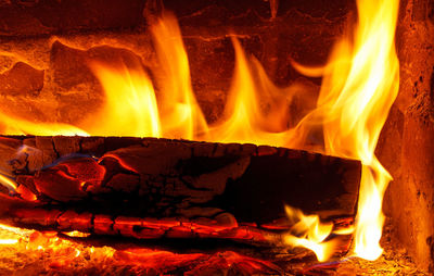 Burning firewood in a brick oven close up