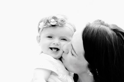 Portrait of happy mother and daughter against white background