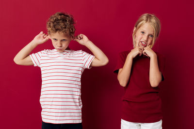 Cute sibling against red background