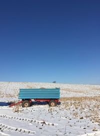 Built structure on field against clear blue sky