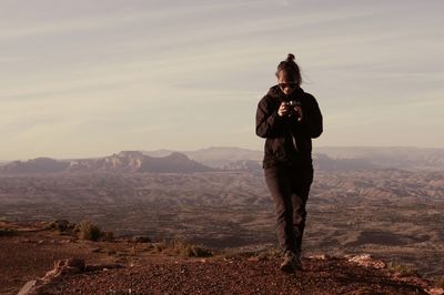 Full length of man standing on mountain against sky