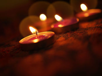 Close-up of lit tea light candles in dark