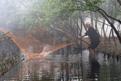 Rear view of man standing in lake