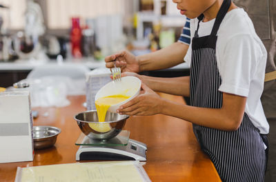 Midsection of man preparing food in kitchen