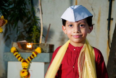 Portrait of smiling boy standing against wall