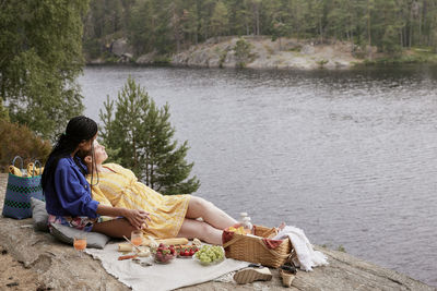 Female couple having picnic by river