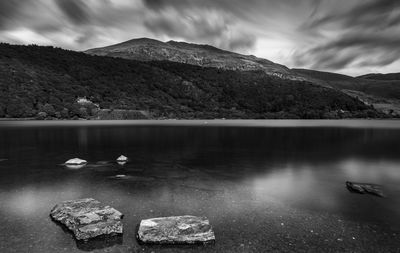 Scenic view of lake by mountain against sky