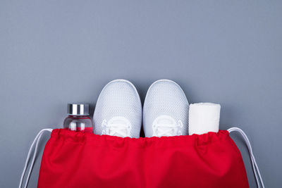 Low section of woman wearing red shoes against white background