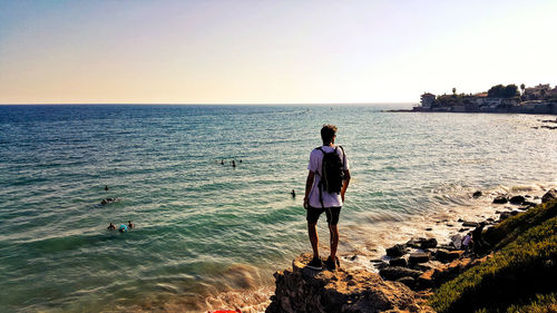 Full length of man standing on beach against clear sky