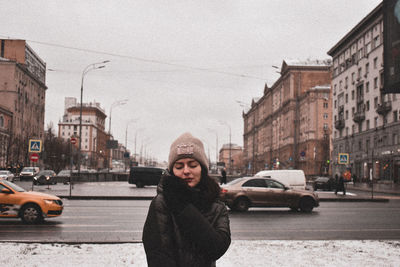 Young woman with closed eyes while standing on city street