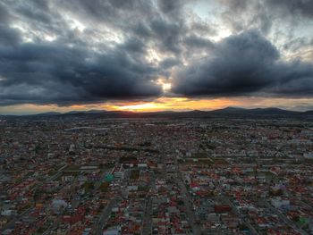 Aerial view of city against dramatic sky
