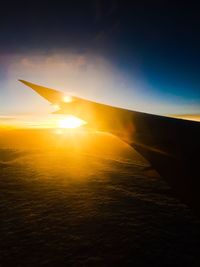 View of airplane wing during sunset