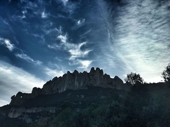 Low angle view of silhouette rocks against sky