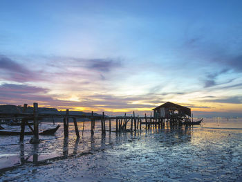Pier over sea against sky during sunset