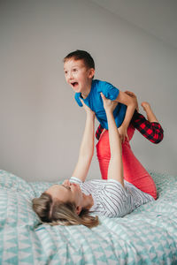 Mother and son playing on bed at home