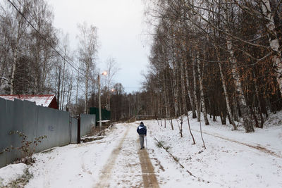 Rear view of person on snow covered land