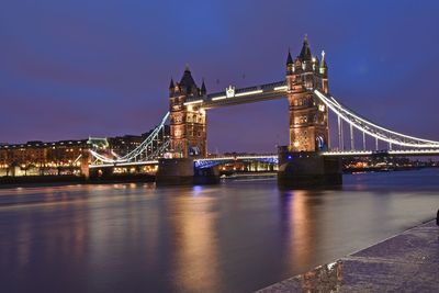 Suspension bridge over river at night