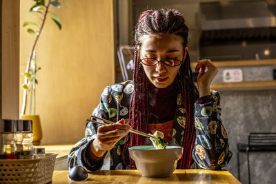 Woman eating food in restaurant