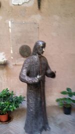 Blurred motion of woman standing by potted plant