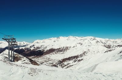 Scenic view of snow covered mountains against clear sky