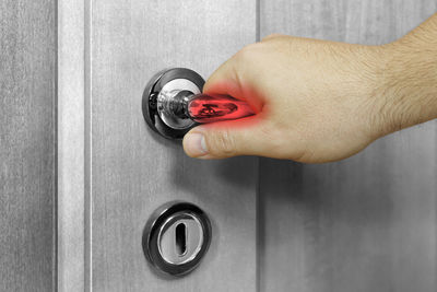 Close-up of hand holding glass door