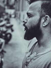 Side view of bearded young man looking away in city