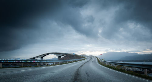 Road leading towards city against sky