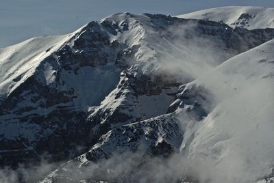 Scenic view of snow covered mountain against cloudy sky