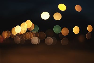 Defocused image of illuminated lights in city at night