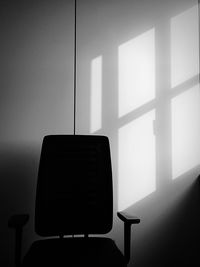 Empty chair and table against wall at home